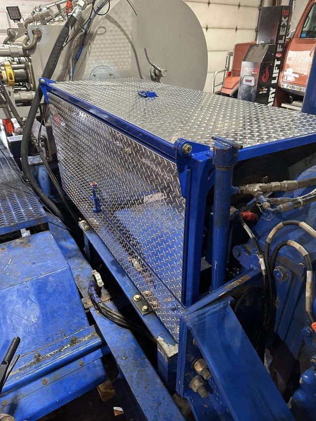 Blue steel skid with a diamond-plate cover and piping