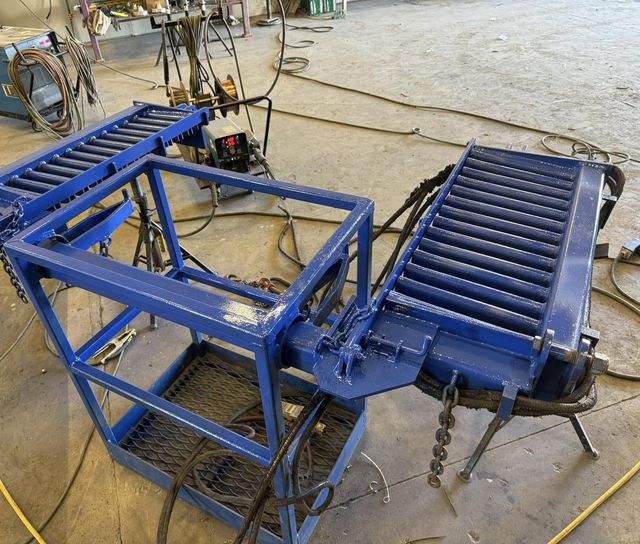 Blue painted custom rod basket with hinged rod finger sections and the HWF storm bar system, on the shop floor