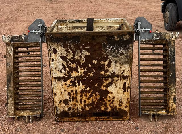 Rusted rod basket and two rod finger sections set out on red gravel, before repair