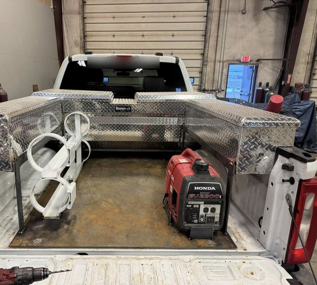 White pickup with a custom service bed: aluminum diamond-plate boxes, a custom rack and a generator