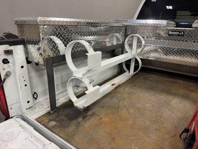 Pickup bed with custom aluminum diamond-plate boxes and a white rack on a steel frame