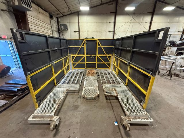 Production rig tubing board with fold-out black steel wind walls, yellow framing and grated walkways in the HWF shop