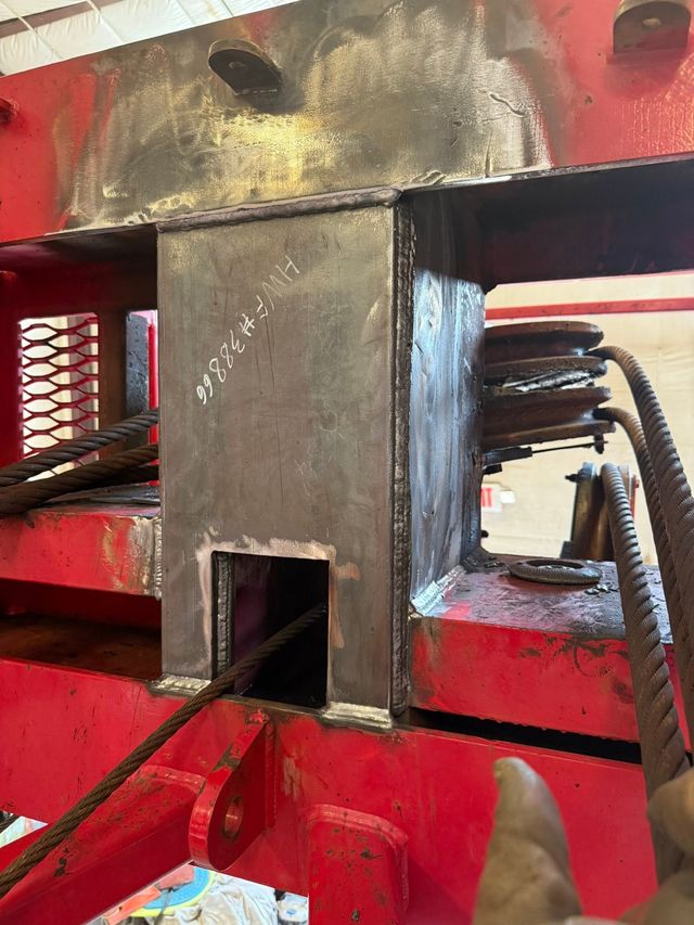 Close-up of heavy steel fabrication and weld repair on red equipment